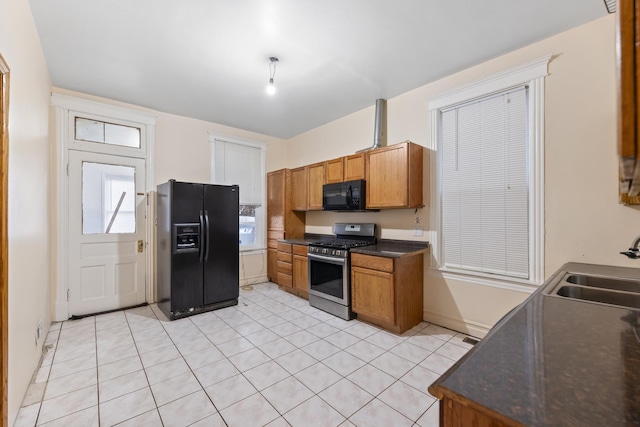 kitchen with black appliances, light tile patterned floors, and sink