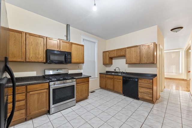 kitchen featuring light tile patterned floors, sink, and black appliances