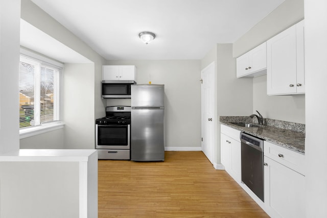 kitchen with light wood-type flooring, white cabinetry, sink, and appliances with stainless steel finishes