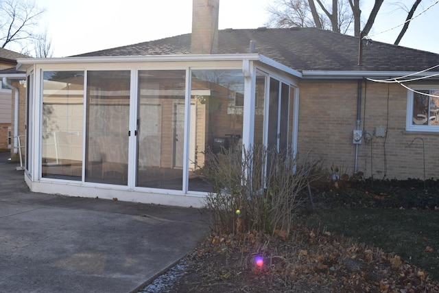 rear view of property featuring a sunroom