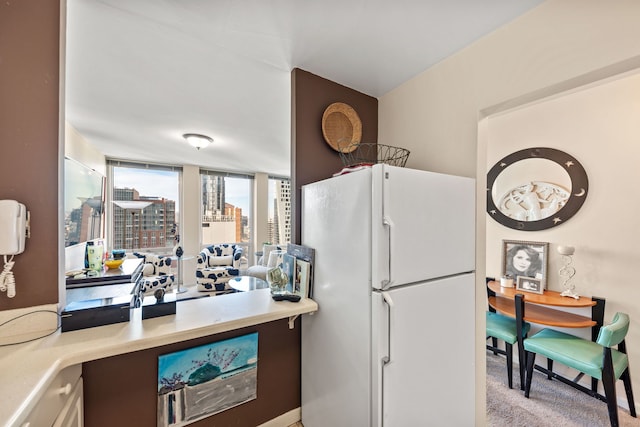 kitchen featuring light carpet and white refrigerator