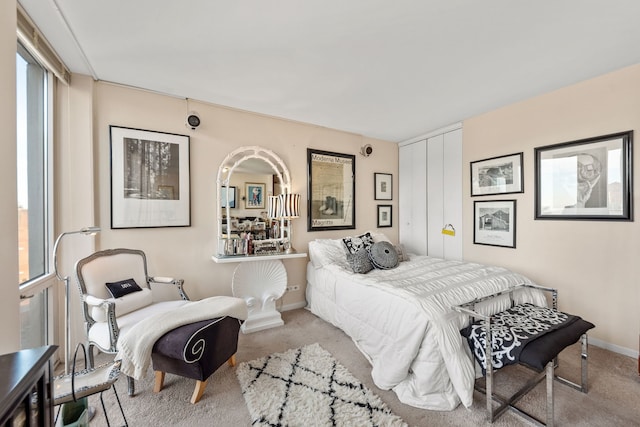 bedroom featuring light carpet and a closet