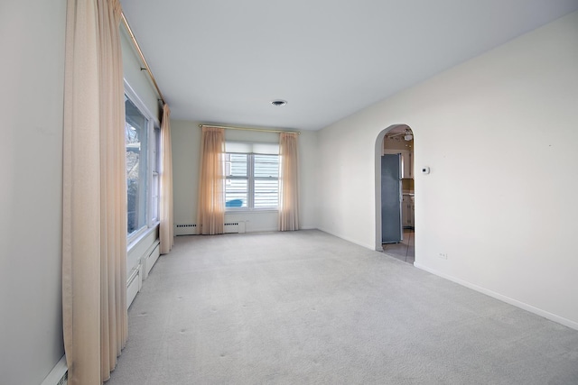 carpeted empty room with a baseboard heating unit