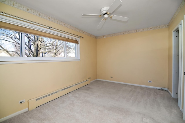 carpeted spare room featuring ceiling fan and a baseboard heating unit