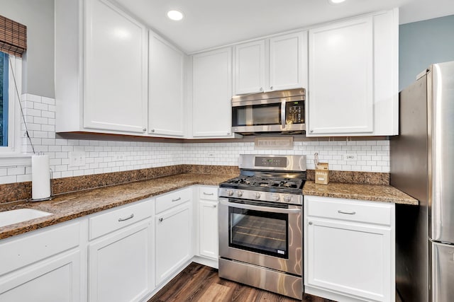 kitchen featuring stainless steel appliances, white cabinetry, and dark hardwood / wood-style floors