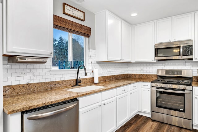 kitchen featuring sink, stainless steel appliances, light stone counters, dark hardwood / wood-style floors, and white cabinets