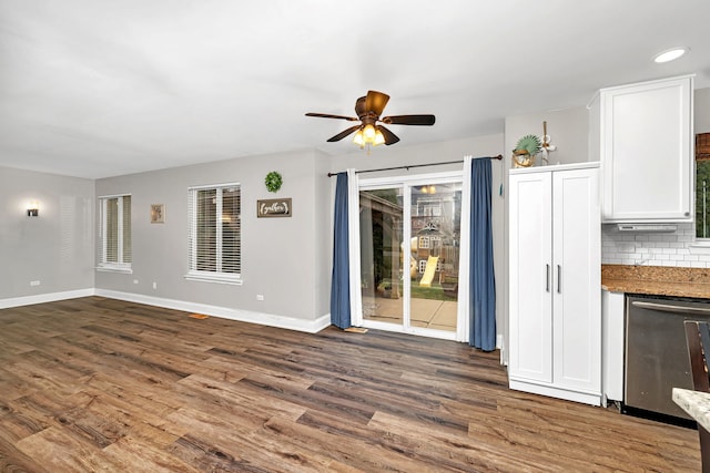 unfurnished living room featuring ceiling fan and dark hardwood / wood-style flooring