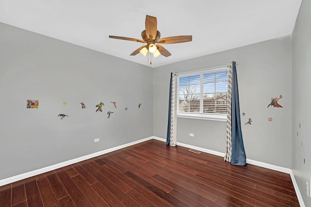 spare room featuring ceiling fan and dark wood-type flooring