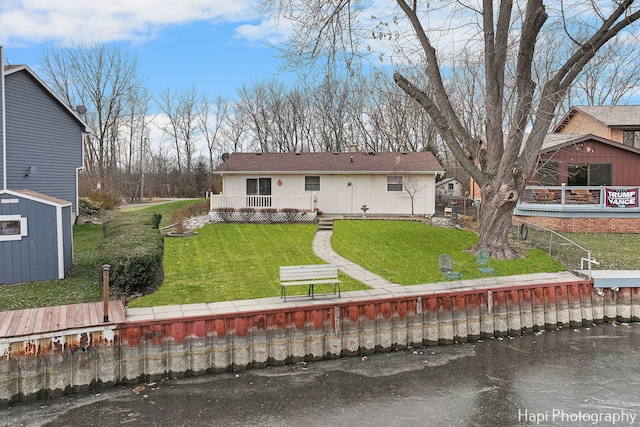 rear view of property with a lawn and a shed