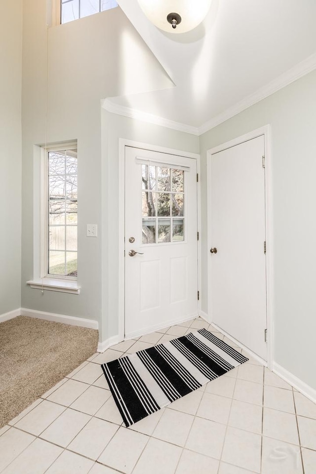 carpeted foyer entrance featuring crown molding