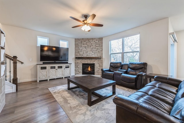 living room with hardwood / wood-style flooring, ceiling fan, and a fireplace