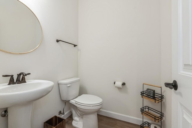 bathroom with hardwood / wood-style flooring, toilet, and sink