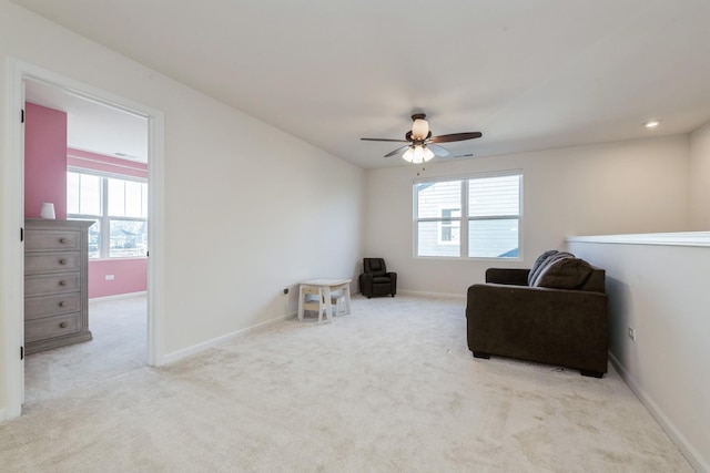 sitting room featuring plenty of natural light, ceiling fan, and light carpet