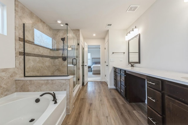 bathroom with hardwood / wood-style floors, vanity, independent shower and bath, and plenty of natural light