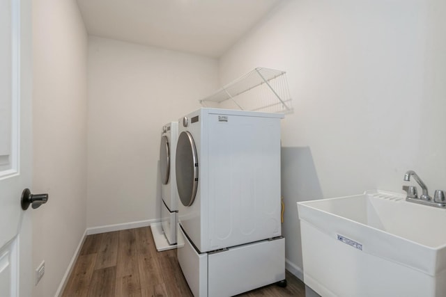 washroom featuring independent washer and dryer, hardwood / wood-style flooring, and sink