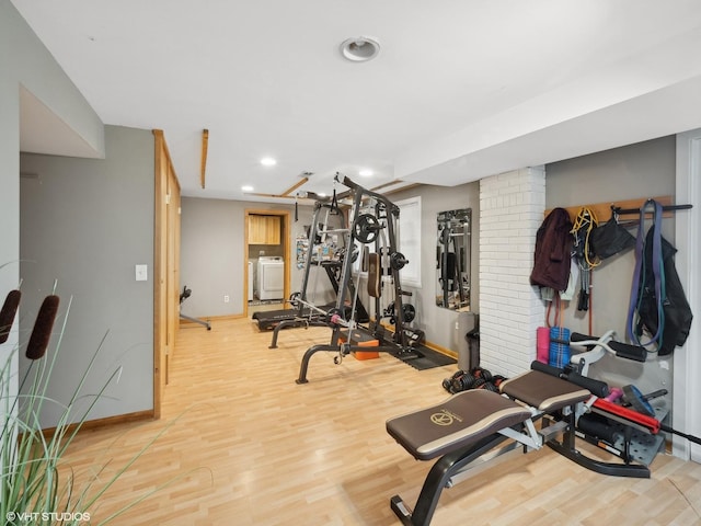 exercise area featuring washer / dryer and light wood-type flooring