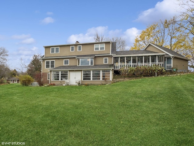 rear view of house with a sunroom and a lawn