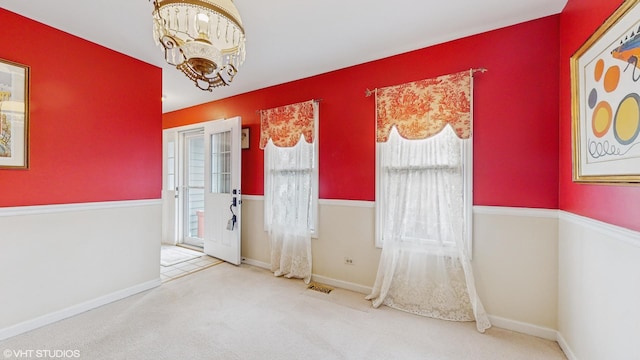 interior space featuring carpet and a chandelier