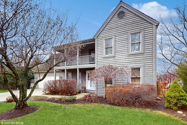 front of property with a front yard, a balcony, and a garage