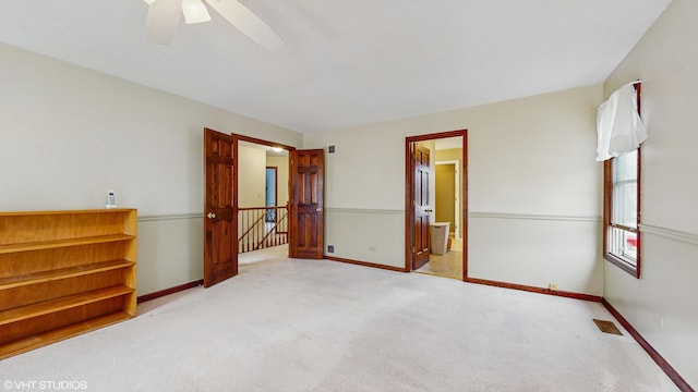 spare room with ceiling fan and light colored carpet