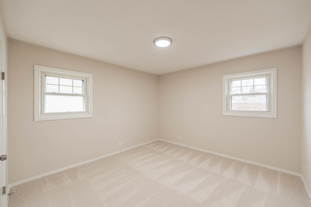 unfurnished room featuring light colored carpet and ornamental molding