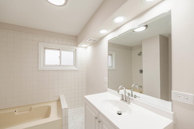 bathroom featuring vanity, tile patterned floors, and tiled shower / bath