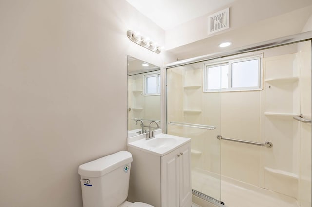 bathroom featuring vanity, toilet, and a shower with shower door