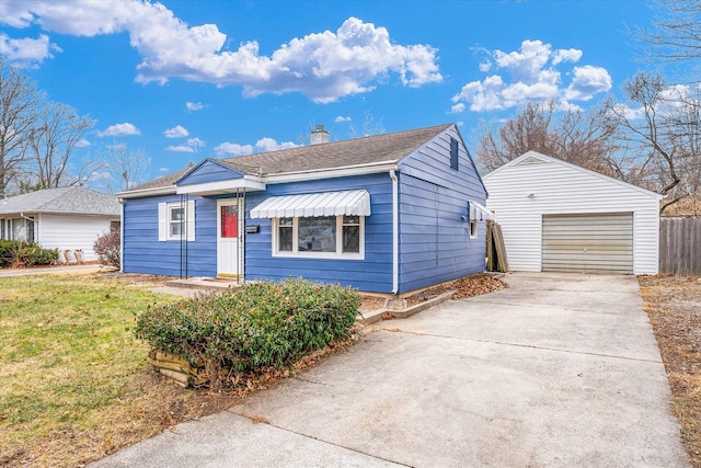 view of front of property featuring an outbuilding, a front lawn, and a garage