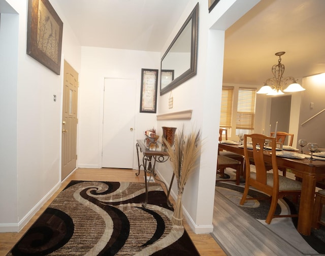 hall with a chandelier and light hardwood / wood-style flooring