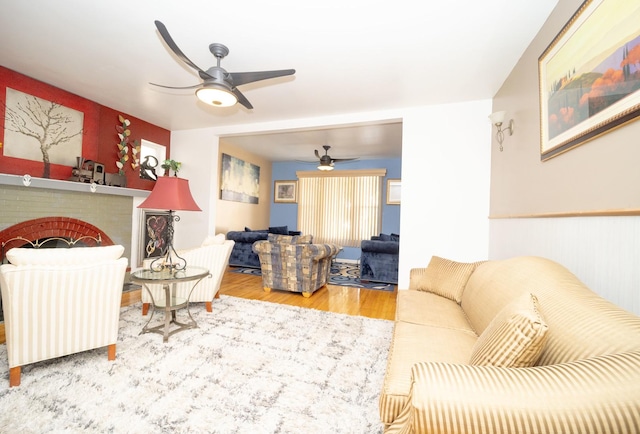 living room with a fireplace, hardwood / wood-style floors, and ceiling fan