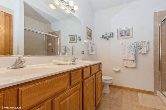 bathroom with toilet, tile patterned flooring, vanity, and walk in shower