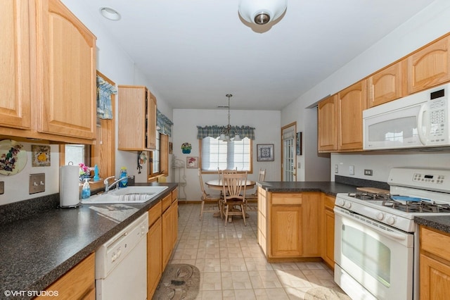 kitchen featuring white appliances, an inviting chandelier, sink, hanging light fixtures, and light brown cabinetry