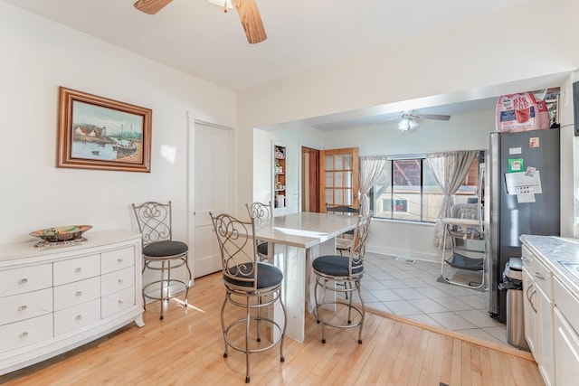 dining space with light hardwood / wood-style flooring and ceiling fan