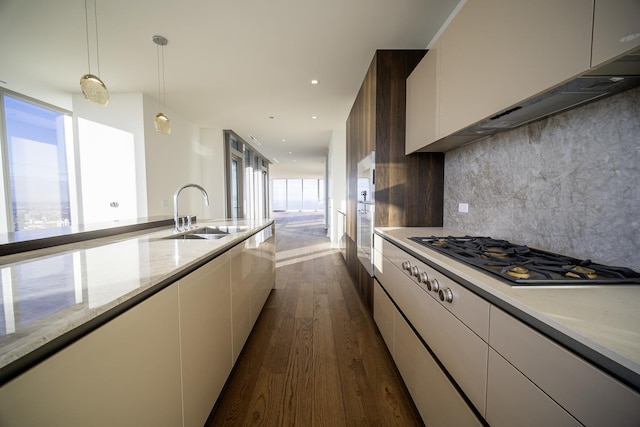 kitchen with stainless steel gas stovetop, dark wood-type flooring, ventilation hood, decorative backsplash, and decorative light fixtures