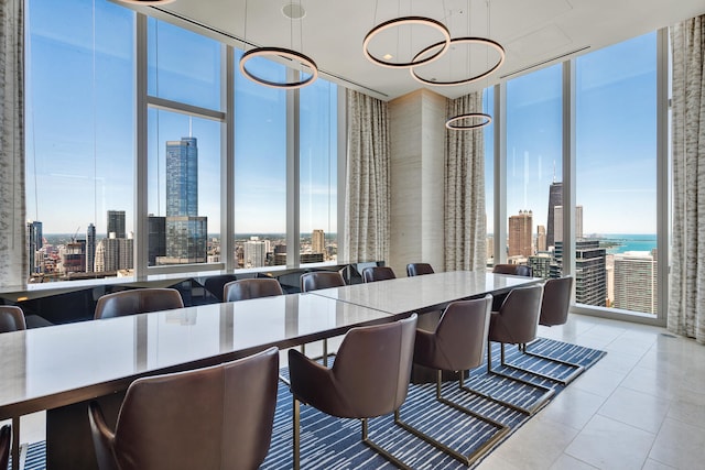 dining area featuring floor to ceiling windows, a water view, and light tile patterned floors