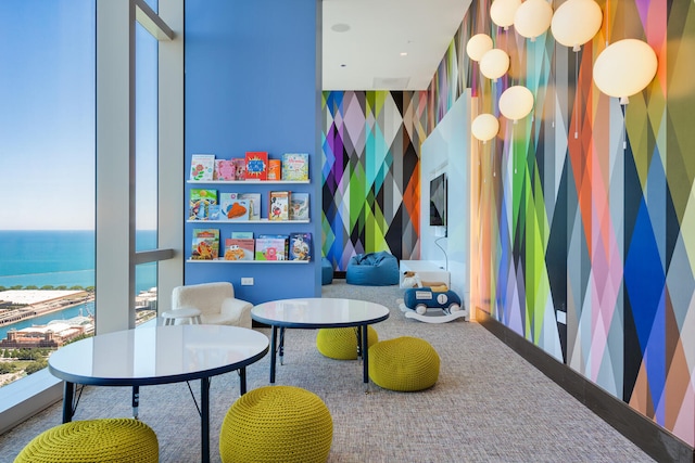 game room featuring carpet floors and a water view