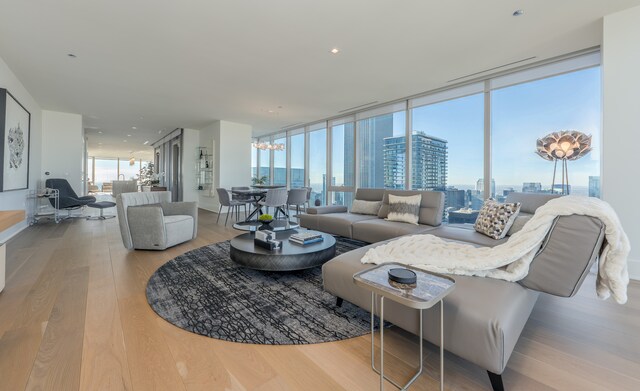 living room with expansive windows, a city view, and wood finished floors