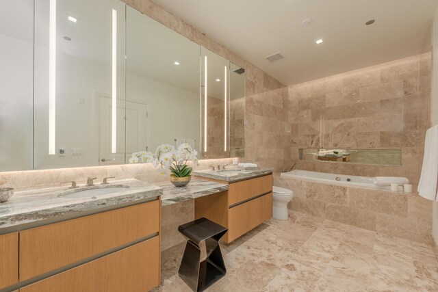 full bathroom with double vanity, a garden tub, visible vents, a sink, and toilet