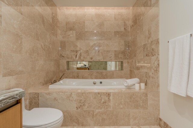 bathroom with vanity, a bath, and toilet