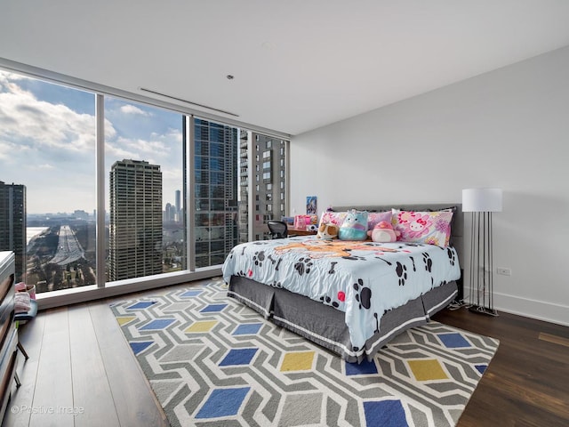 bedroom featuring dark hardwood / wood-style flooring and a wall of windows