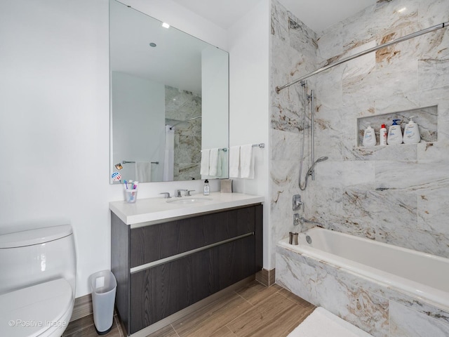 full bathroom with vanity, tiled shower / bath combo, and toilet