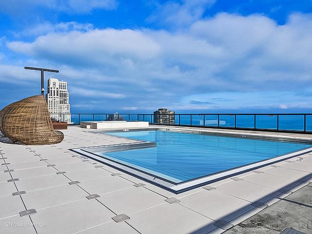 view of swimming pool featuring a patio area and a water view