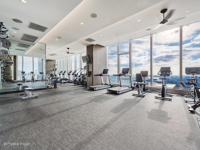 exercise room featuring floor to ceiling windows, ceiling fan, and carpet floors