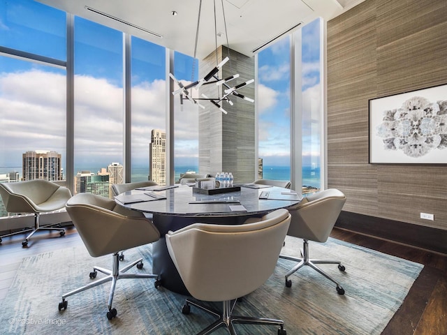 office with floor to ceiling windows, a water view, and dark hardwood / wood-style floors