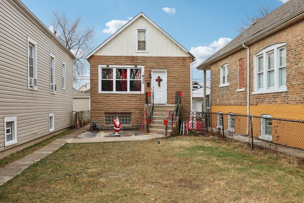 rear view of property featuring a lawn