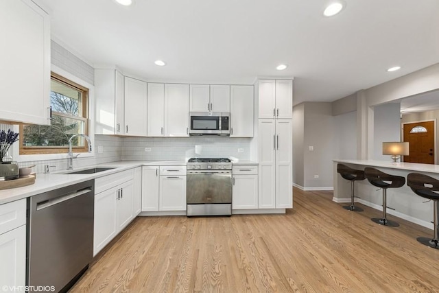 kitchen with sink, stainless steel appliances, and white cabinetry