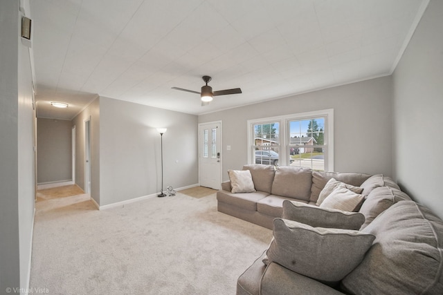 living room featuring ceiling fan, light colored carpet, and crown molding