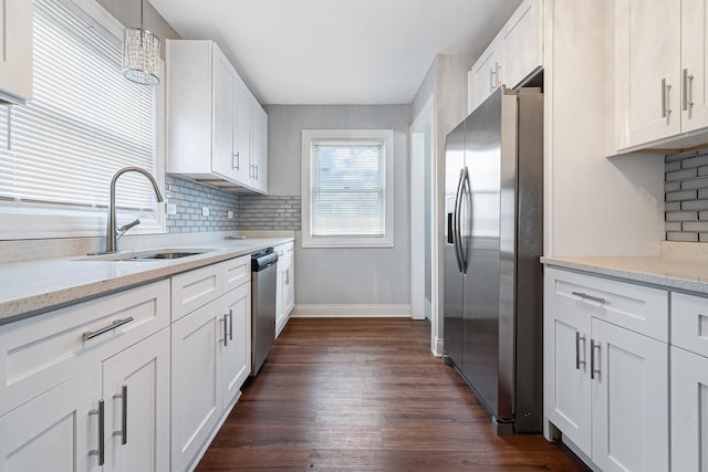 kitchen featuring white cabinetry, stainless steel appliances, sink, and pendant lighting