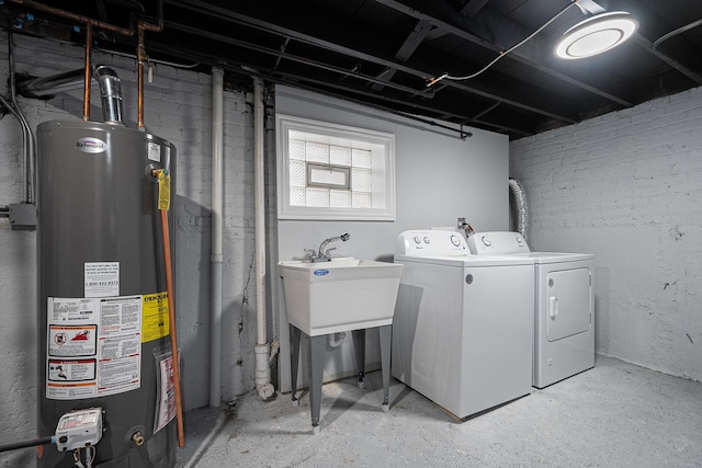 laundry area with washing machine and clothes dryer, sink, and gas water heater