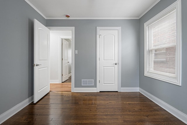 unfurnished bedroom featuring ornamental molding and dark hardwood / wood-style floors